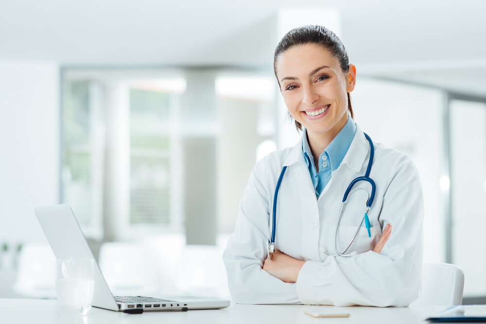Confident female doctor at office desk